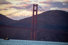 Small boat below golden gate bridge